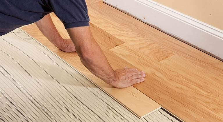 Man installing fitting new wood flooring
