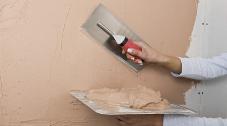 Plastering and applying skim coat to walls