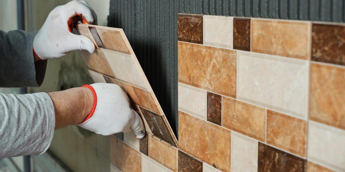 Tradesman tiling a wall in a London home